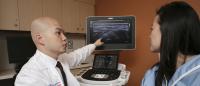 Musculoskeletal radiologist does ultrasound on female patient's arm